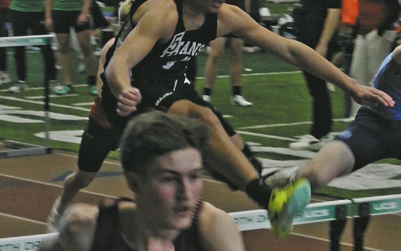 Titan sophomore Mason Pollestad clears the hurdle in the Boys 60M Hurdles. Pollestad secured a place in the finals, placing 5th with a new personal record. Photo by Jamie Rarick