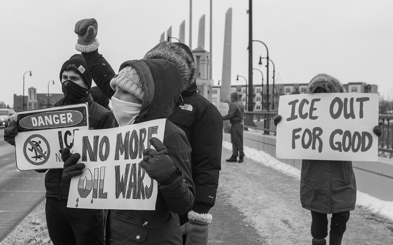 Protestors hold up homemade signs along the Veterans Memorial Bridge in Fargo on Saturday, Jan. 10, 2026, during a protest of ICE and the US involvement in Venezuela. Alyssa Goelzer / The Forum