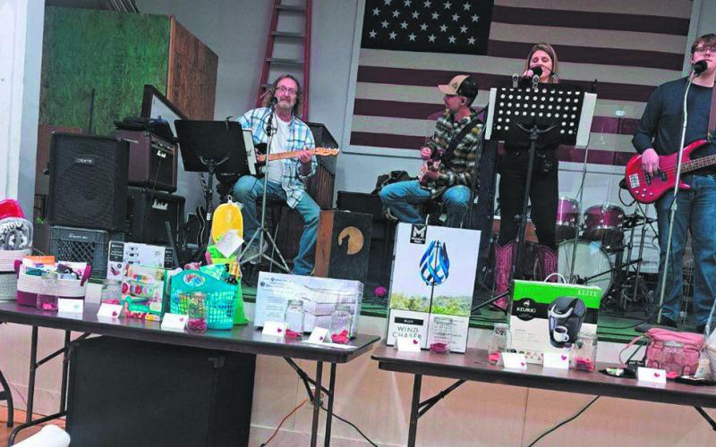 The Homestead Band played on the stage behind a large display of items and baskets that had been donated for the silent auction. Photo by Christine Jensen