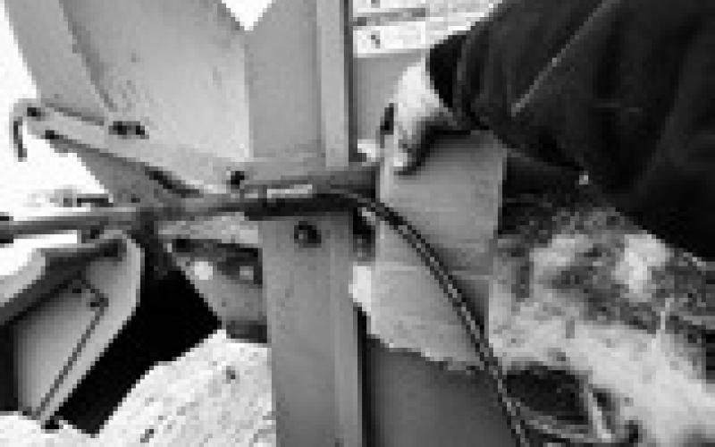 Pinhole leaks in hydraulic hose lines are extremely dangerous and can be impossible to see with the naked eye. Using a piece of cardboard to check for leaks protects hands and fingers. (NDSU photo)
