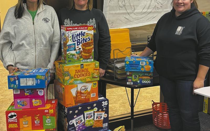 From left to right: Tara Jarshaw, Jami Melland, and Samantha Bratlie drop off snacks for elementary schoolers.