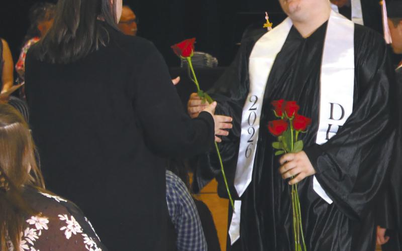 Grant Uggerud handing a rose to his mother during his Graduation ceremony last Sunday Photo by Andrea Johnston