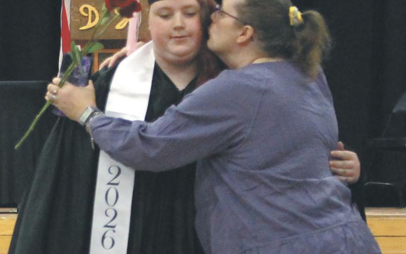 Stephanie Kissee receiving a congratulatory embrace from her mother while leaving graduation. Photo by Andrea Johnston
