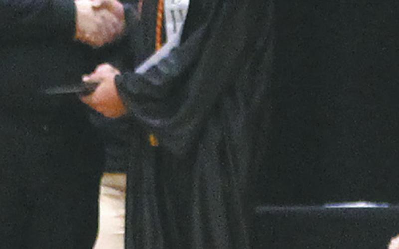 Ryan Corrick looked back at the crowd as he accepted his diploma. Photo by Andrea Johnston