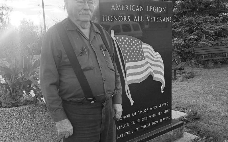 Bellamy stands beside an American Legion Veterans Memorial. Photo by Christine Jensen.
