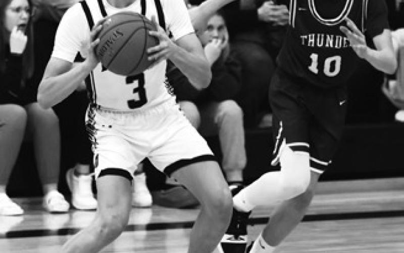Everett Fedje and Calvin Otto try to stop Hatton-Northwood's Derek Carpenter. Photo by Lyle Van Camp.