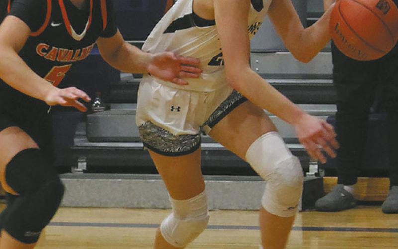 DVE senior Jaelyn Johnson drives toward the basket past Cavalier junior Colbie Furstenau. Photo by Jamie Rarick