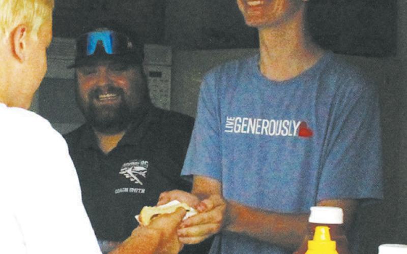 Jonah Rarick and Raven Smith helped serve concessions at Schumacher Park on Friday as a fundraiser for the Bomber football team.