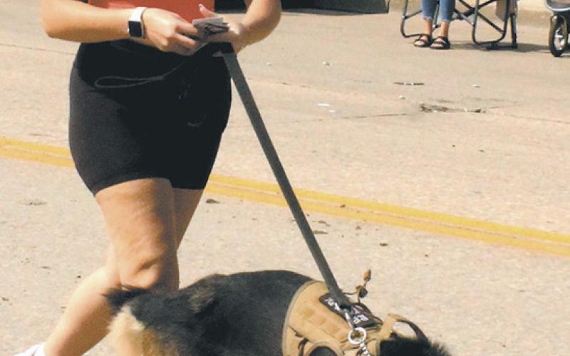 Rylee Maurstad and K-9 officer Freeway visited with the crowd during Saturday's parade. Photo by Jamie Rarick