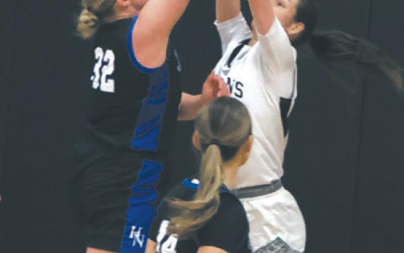 Hatton-Northwood's Elizabeth Pinke goes for the shot as DVE's Elizabeth Fedje leaps for the block. Photo by Jamie Rarick
