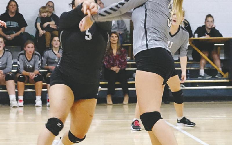 Emily Gonzalez and Claire Thompson both go for a dig against the NB Eagles. Photo by Larry Stokke.
