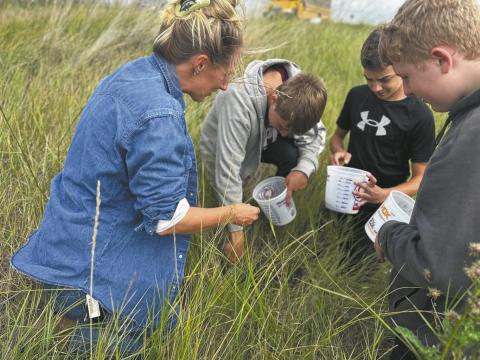 Artist Austen Camille [left] along with North Valley CTE students Aaron Linner, Kale Tanke, and James Elliott collecting prairie soils they later rendered into paint pigments during the Thinking Like a Prairie workshops. Photo provided by Josh Anderson.