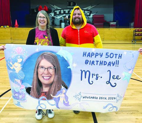 Mrs. Lee and DHS Athletic Director Raven Smith with her birthday banner. Photo courtesy of Drayton School.