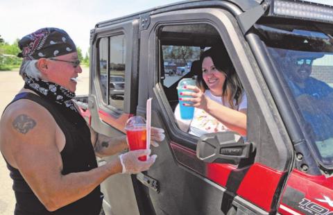 Jeff Baker, left, serves up two of his Rez Famous Lemonade drinks to Kirsten Azure at the Jollie’s Mall parking lot in Belcourt, located on the Turtle Mountain Reservation in Rolette County. Photo courtesy of Turtle Mountain Star, Rolla