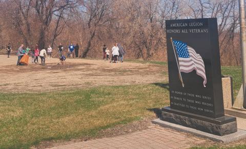 DPS students clean up the dike behind the monument that honors their ancestors. Photo by Christine Jensen