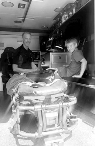 Volunteer emergency responder, Rob Boll showing the ambulance to nephew, Ethan Boll. Photo by Christine Jensen.