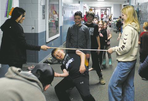 High school students helped with a limbo contest in the halls during Drayton School's family night. Photo by Jamie Rarick