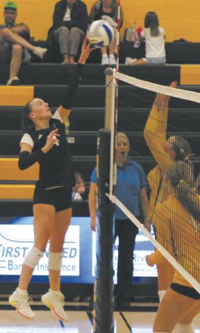 Extending over the net, DVE junior Jocelyn Vold tips the ball against Park River defenders. Photo by Jamie Rarick