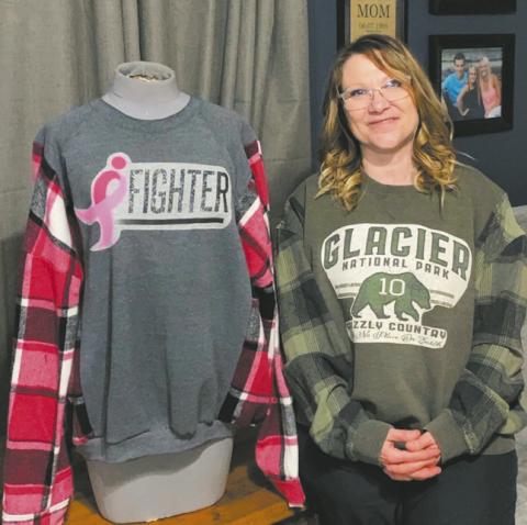 Jamie Mattice wears the first sweatshirt she created from a t-shirt she received from her daughter, Rylee, while standing next to one of her Re-Loveables sweatshirts. Photo by Rylee Maurstad