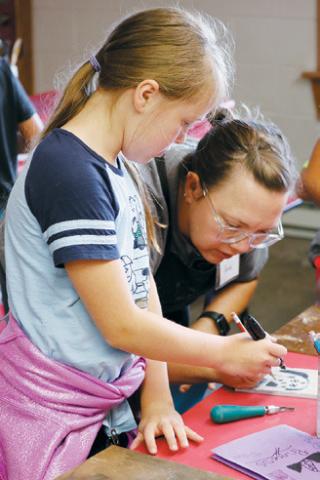 Art instructor, Anna Jacobsen demonstrates how to carve a linoleum printing plate.