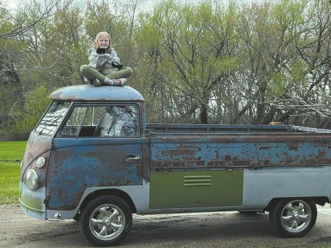 Aurora Jo Jensen holding cat, Bert, on top if the Jensen’s VW pickup. Photo by Christine Jensen.