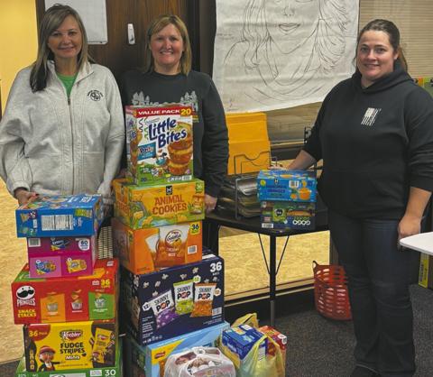 From left to right: Tara Jarshaw, Jami Melland, and Samantha Bratlie drop off snacks for elementary schoolers.