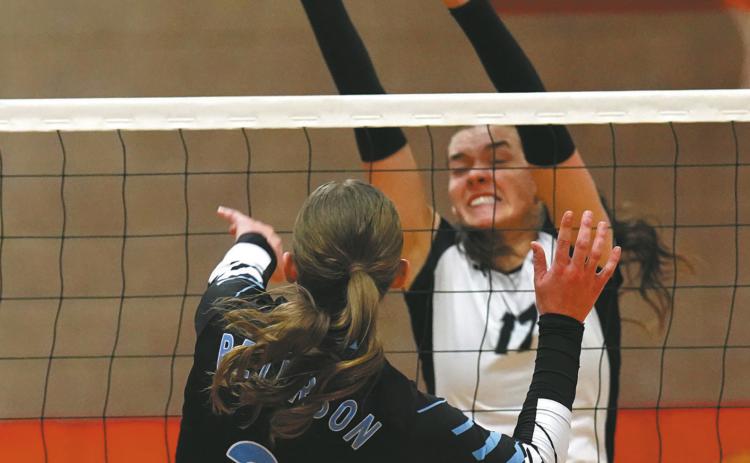 Senior Elizabeth Fedje goes for the block. Photo by Larry Stokke.
