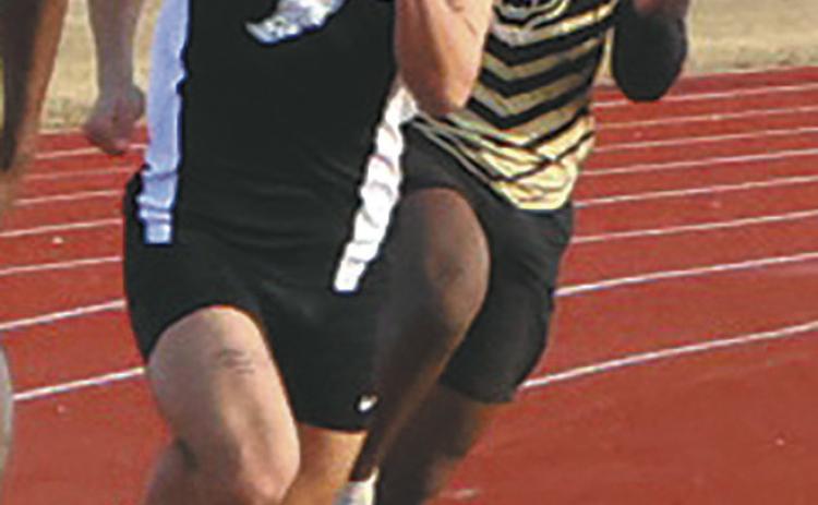 Fighting through the wind and cold, sprinters, including DVE junior Trenten Keena, rounded the track during the Mens 200m dash. Keena earned a 7th-place finish in the competitive event. Photo by Jamie Rarick