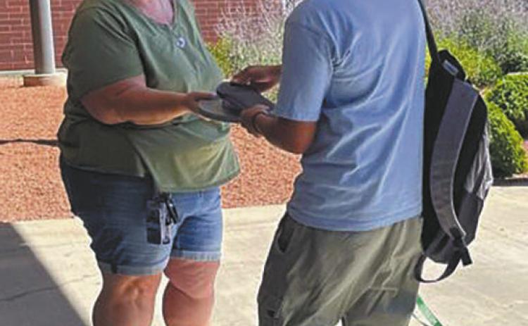 High school students unlock magnetic locking pouches containing their phones after class with a newly established a phonefree policy in 2024. After the success of cellphone bans nationwide, state lawmakers are turning to legislation restricting how much time students can look at screen. (Alixel Cabrera/Utah News Dispatch)