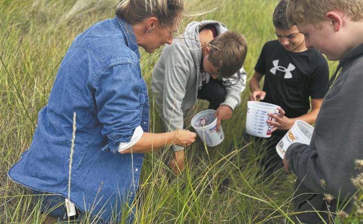 Artist Austen Camille [left] along with North Valley CTE students Aaron Linner, Kale Tanke, and James Elliott collecting prairie soils they later rendered into paint pigments during the Thinking Like a Prairie workshops. Photo provided by Josh Anderson.