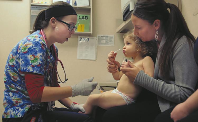 Nurse Julianna Emanuel administers a hepatitis A vaccine shot at the Sanford Children's Clinic in Fargo. Photo by Dave Wallis, courtesy of The Forum.