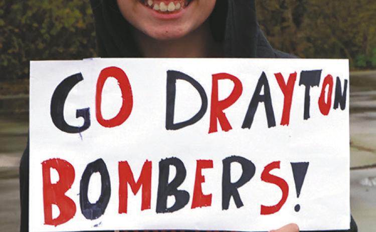 Ruthie Rarick holds up a sign supporting the team as they head for Minot. Photo by Lyle Van Camp