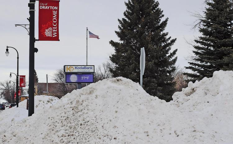 The electronic sign seen in the background beyond the snowpiles created from the street plowing showed a temperature of 37 degrees on Tuesday afternoon. VNV Picture by Lesa Van Camp