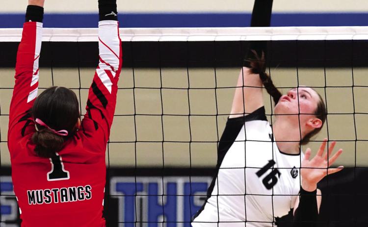 Ingrid Myrdal slams the ball over the net towards Mustangs' senior Sadie Armbrust. Photo by Larry Stokke