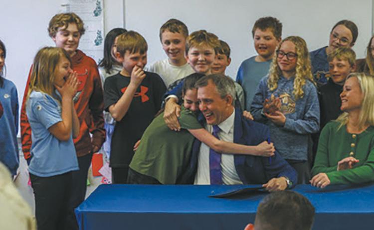 A student at Centennial Elementary gives Gov. Kelly Armstrong a hug after he gave her the pen he used to sign House Bill 1160, which requires North Dakota public schools to adopt phone-free school policies, on Friday, April 25. Submitted photo.