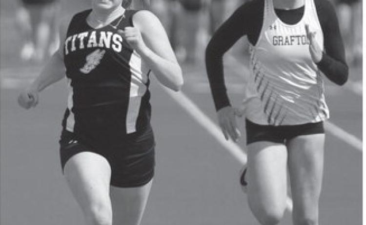 Greta Burrell, left, took first in her heat in the 100 meter dash. At right is Grafton Junior Molly Bjorneby.