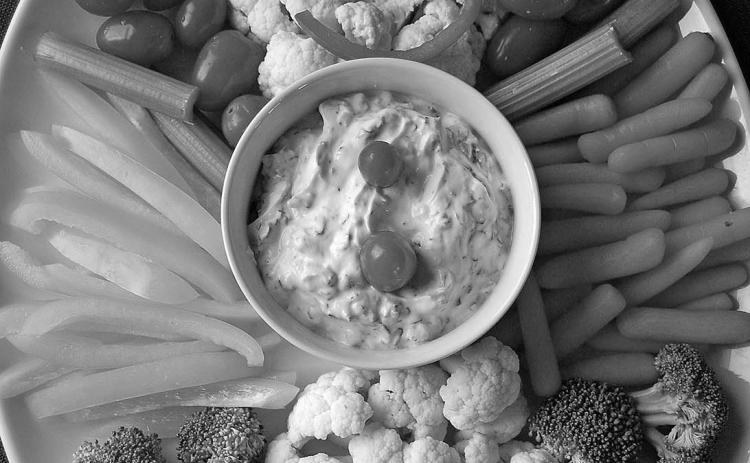 Bring a healthful dish to your next holiday party. How about a veggie tray shaped like a snowman with spinach dip? Photo by Pixabay.