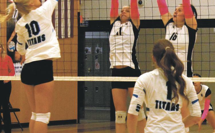 Alyssa Hoyles and Ingrid Myrdal leap into the air in an attempt to block a Griggs Midkota hit. Photo by Jamie Rarick