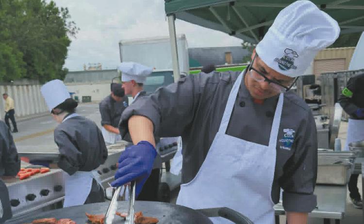 Jerimiah Johnson prepares lamb chops for his entree. Photo by Yvonne Johnson.