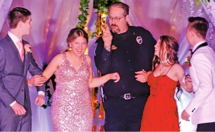 Drayton City Officer Ian Mattice let the boys know that he had his eyes on them and then escorted their dates through the walkway of the Grand March Pictured l to r: Evan Feltman, Rylee Maurstad, Officer Mattice, Jazalyn Rathke, and Hunter Johnson. VNV Photo by Lesa Van Camp