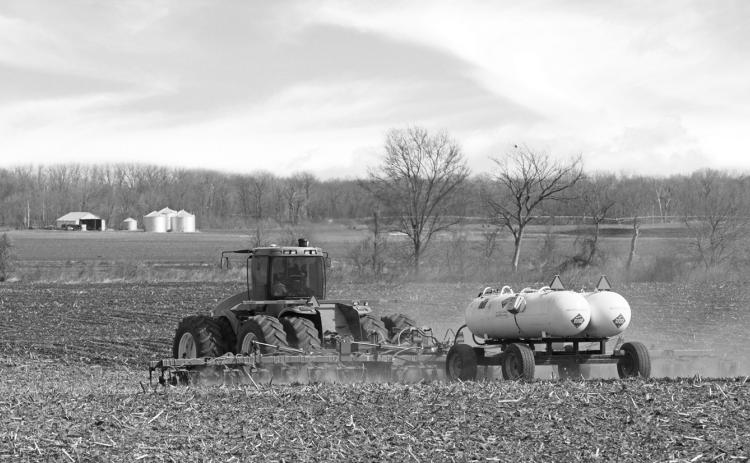 A tractor pulls anhydrous ammonia tanks to fertilize a farm field. (iStock Getty Images Plus)