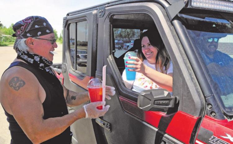 Jeff Baker, left, serves up two of his Rez Famous Lemonade drinks to Kirsten Azure at the Jollie’s Mall parking lot in Belcourt, located on the Turtle Mountain Reservation in Rolette County. Photo courtesy of Turtle Mountain Star, Rolla