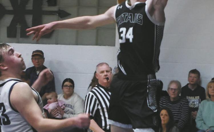 Extending for the basket, DVE senior Jack Langerud leaps past North Border defender Kade Schafer for the shot. Photo by Jamie Rarick