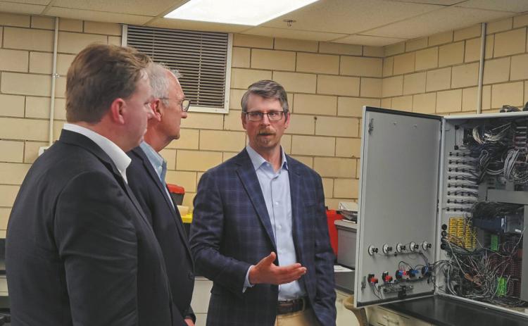 Dan Laudal, executive director and research professor with the University of North Dakota College of Engineering and Mines, provides a tour of the critical minerals research facility in Grand Forks on May 26, 2026, to Sen. Kevin Cramer, center, and Department of Defense official Michael Duffey. (Photo by Jeff Beach/North Dakota Monitor)