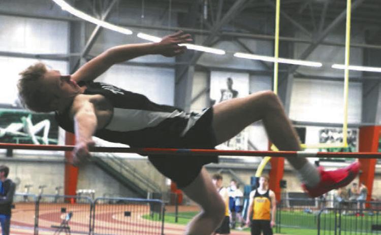 Carter Oberg fights his way over the bar in the boys high jump. Photo by Lyle Van Camp.