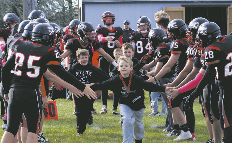 Bomber Buddies Pearce Pokrzywinski and Thomas Manley ran through the lineup with senior Trenten Keena before Saturday's game. Photo by Jamie Rarick