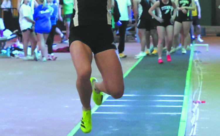Launching off the runway, DVE senior Elizabeth Fedje flies through the air in the Women's Long Jump competition. Fedje finished second in the event with a distance of 15' 7'. Photo by Jamie Rarick