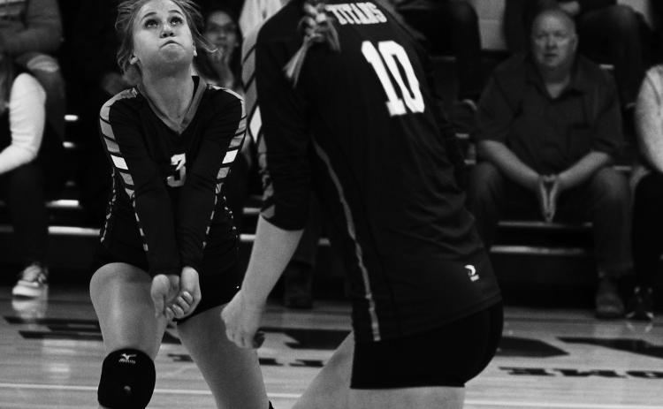 Junior Claire Thompson (3) passes the ball as sophomore Easton Larson gets ready to hit in Friday's final match of the year vs. North Border in Pembina. Photo by Mike Alan Steinfeldt.