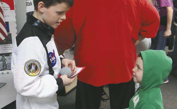 Calvin Helm is entertained by his big brother Henry Helm's presentation about the first astronaut on the moon, Neil Armstrong. Photo by Jamie Rarick