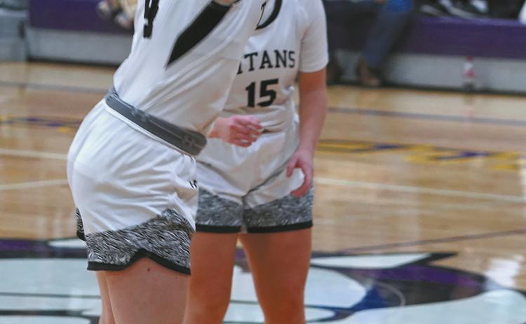 Gretta Burrell sinks a long three point shot against the NP Cougars. Photo by Larry Stokke